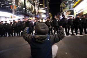 Protester faces NYPD in Times Square (photo: AP)