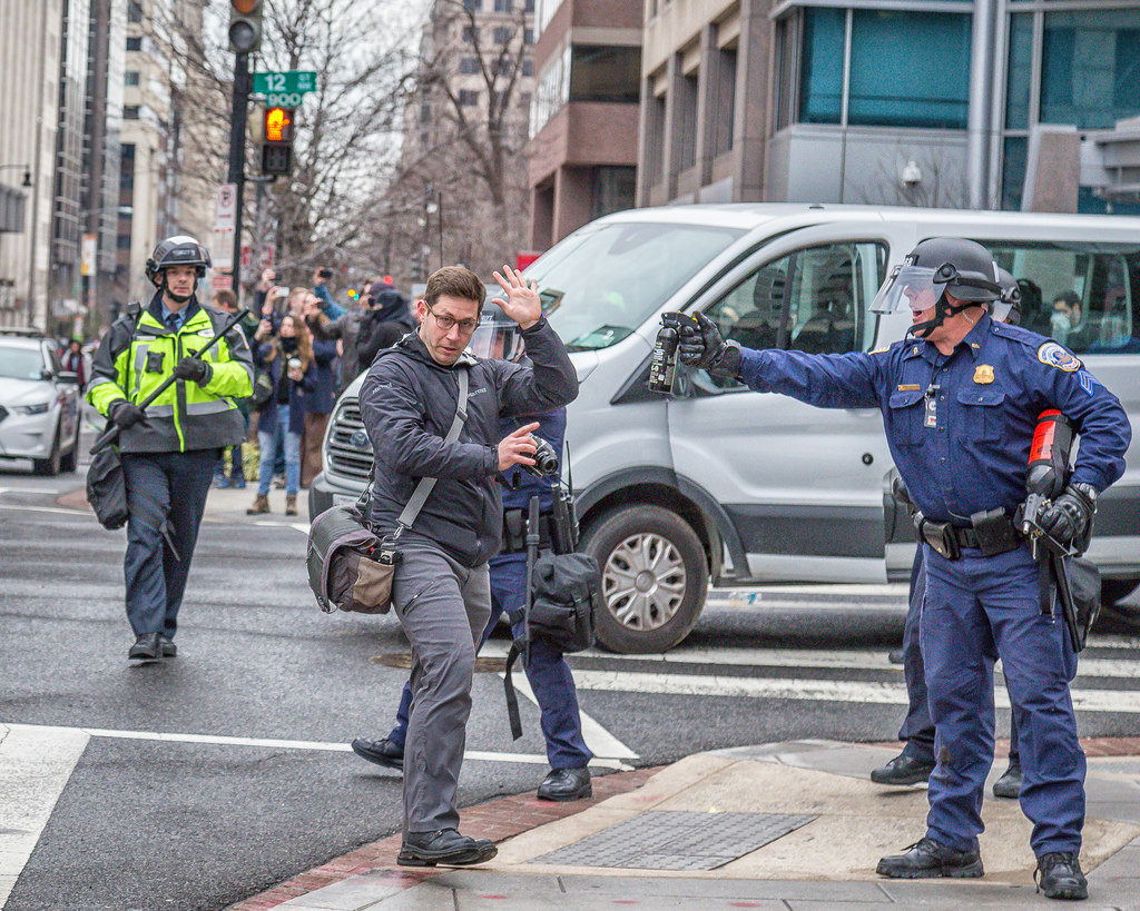 Police officer threatens photographer with pepper spray during inauguration protests (cc photo: Mobilus In Mobili)