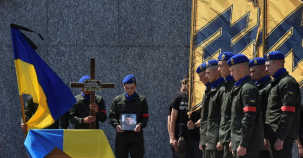 Photo of an Azov memorial service featuring flags with an SS symbol, used by Engadget to illustrate a story on Facebook's Azov reversal.