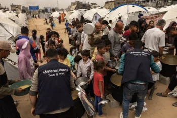 "Lining up for food at a charity kitchen in Jabaliya, Gaza, this month." Photo by Saher Alghorra for the New York Times