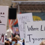 Protest signs: 'Tear Gas Tastes Like Fascism'; 'Where Law Ends, Tyranny Begins'